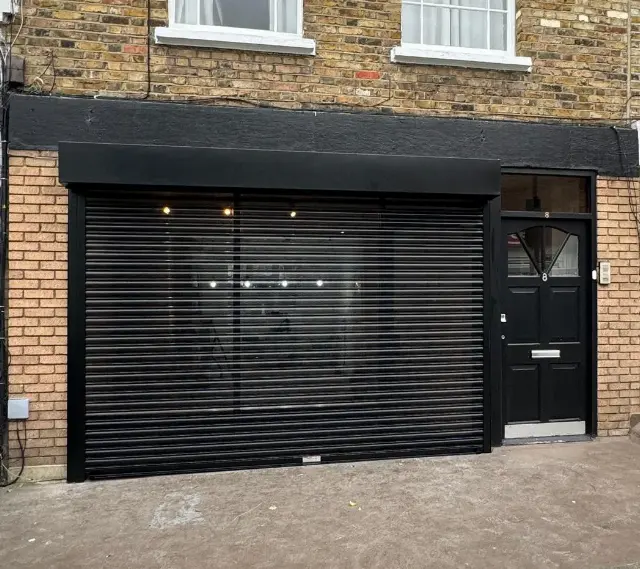 Black solid roller shutter installed on a commercial unit