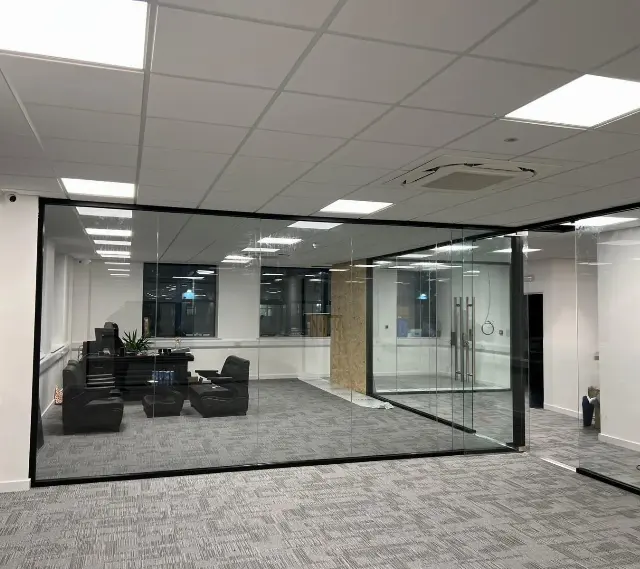 Frameless glass office partitions in an open-plan workspace