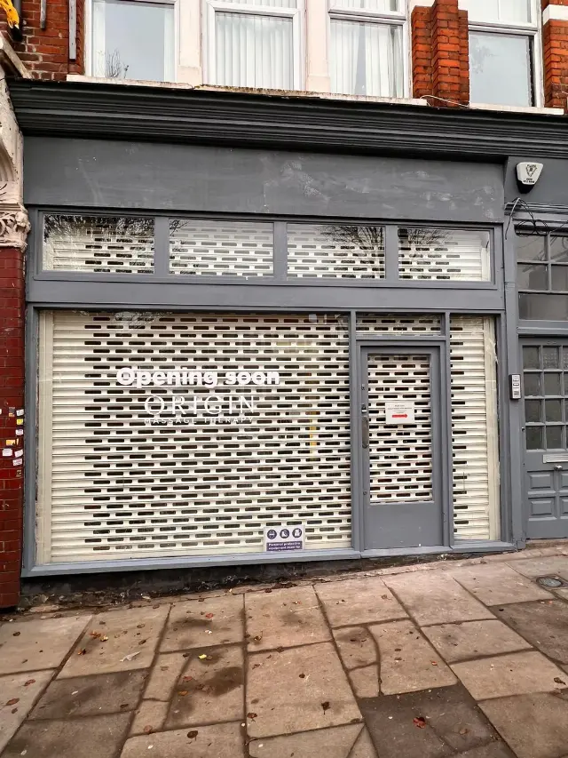 White perforated roller shutter for Origin Massage Therapy
