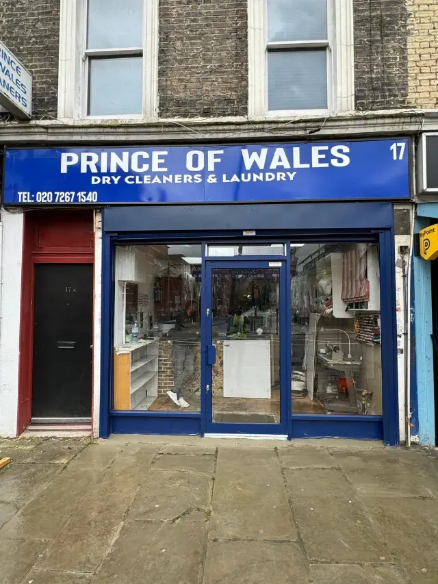 Blue shopfront with glazed door for Prince of Wales Dry Cleaners