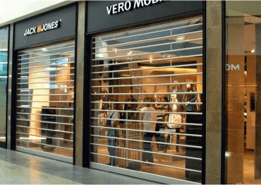 Transparent rolling grille shutters securing a retail shop front